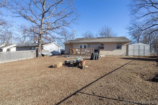 back of house featuring a wooden deck and a storage unit