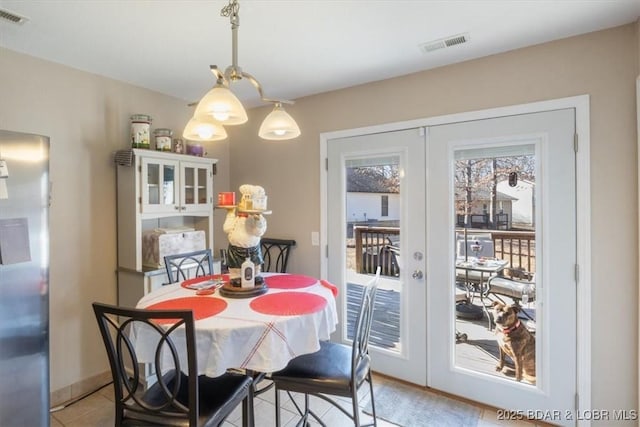 tiled dining room featuring french doors