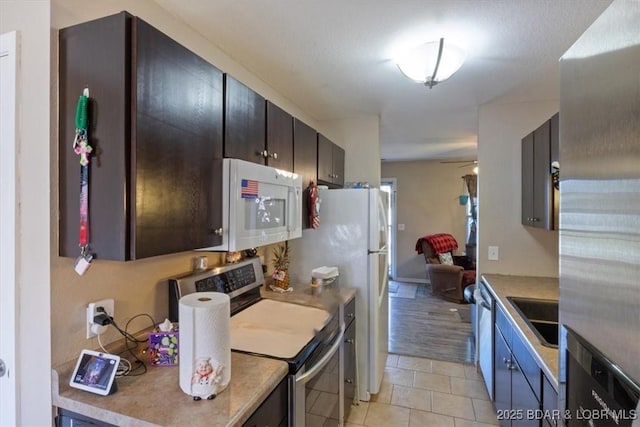 kitchen featuring sink, light tile patterned floors, and appliances with stainless steel finishes