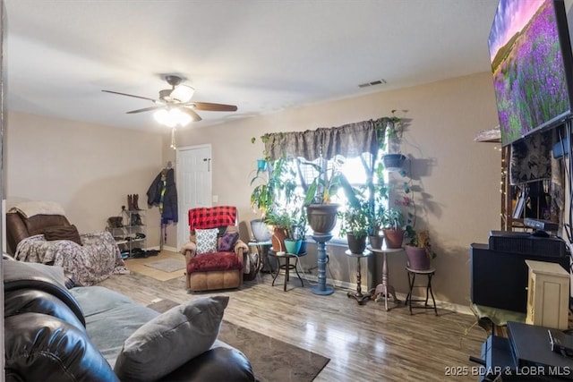 living room featuring hardwood / wood-style floors and ceiling fan