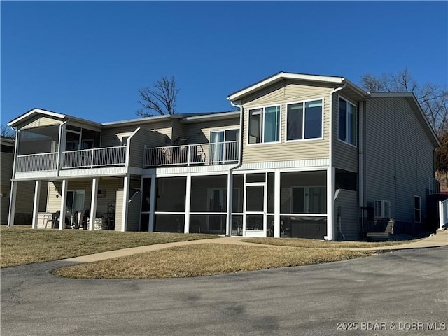 view of front of home featuring a front lawn and a sunroom