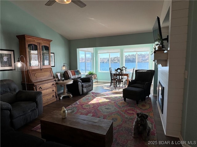 living room with dark wood-type flooring, ceiling fan, and vaulted ceiling