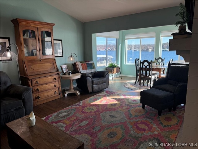 living room featuring vaulted ceiling, a water view, and dark hardwood / wood-style floors