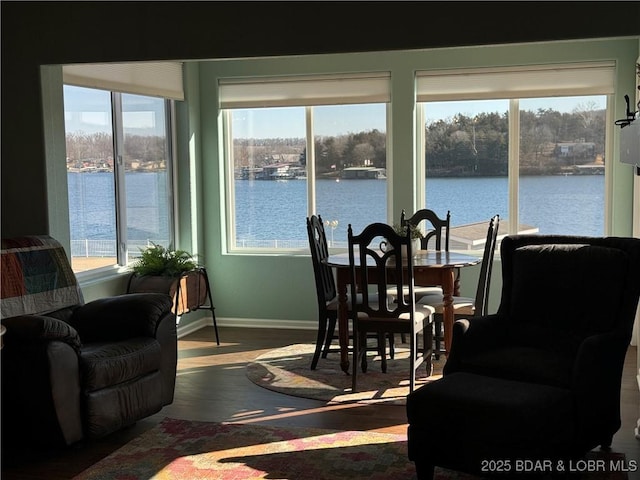 dining area featuring wood-type flooring and a water view