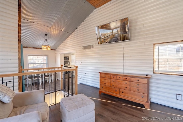 living room with dark wood-type flooring and high vaulted ceiling