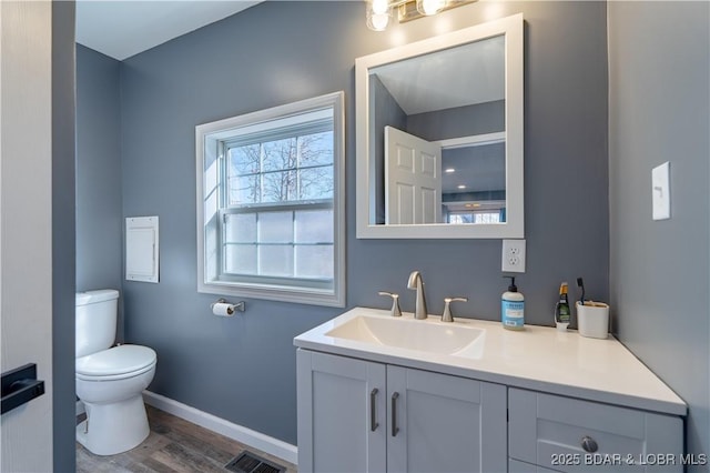 bathroom with vanity, wood-type flooring, and toilet