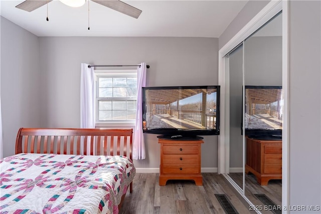 bedroom with wood-type flooring, ceiling fan, and a closet