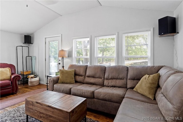 living room with vaulted ceiling, a healthy amount of sunlight, and dark hardwood / wood-style flooring