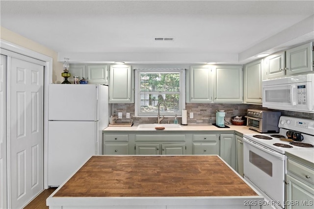 kitchen with tasteful backsplash, sink, and white appliances