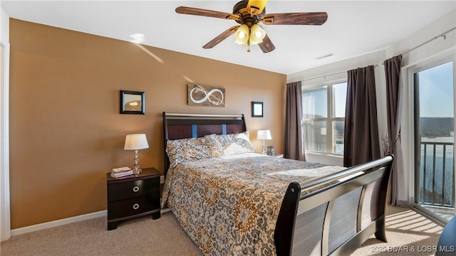 bedroom with multiple windows, light carpet, access to exterior, and ceiling fan