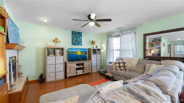 living room featuring ceiling fan and dark hardwood / wood-style flooring