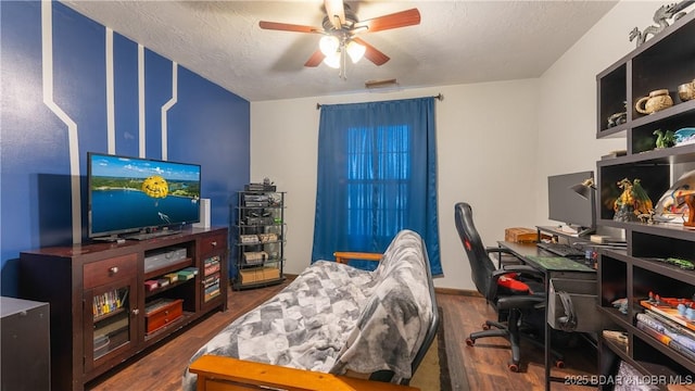 interior space featuring ceiling fan, dark wood-type flooring, and a textured ceiling