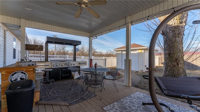 view of patio / terrace with ceiling fan and a storage unit