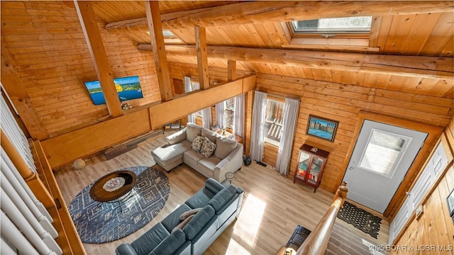 unfurnished living room with lofted ceiling with skylight, wooden ceiling, and light hardwood / wood-style floors