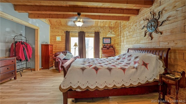 bedroom with beam ceiling, wooden ceiling, wooden walls, and wood finished floors