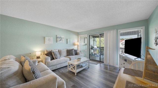 living room featuring dark wood-type flooring and a textured ceiling