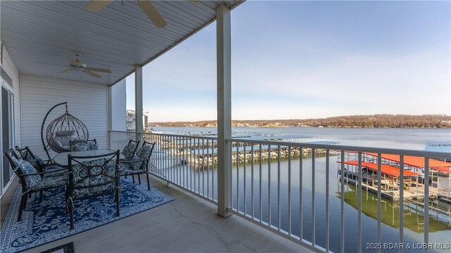 balcony featuring a water view and ceiling fan