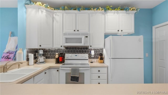 kitchen with sink, white cabinets, and white appliances