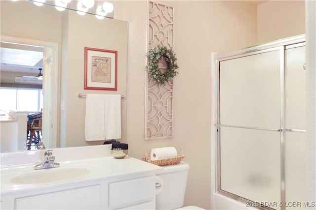 full bathroom featuring shower / bath combination with glass door, vanity, and toilet