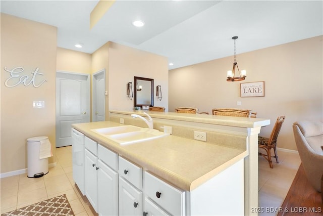 kitchen with pendant lighting, sink, a center island with sink, and white cabinets