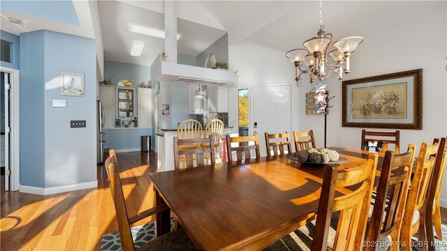 dining space featuring vaulted ceiling, a chandelier, and wood-type flooring