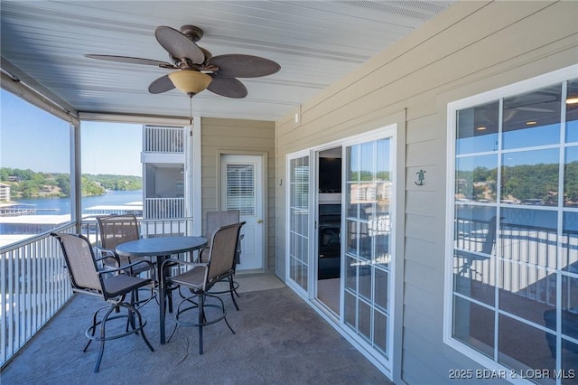 sunroom with a water view and ceiling fan