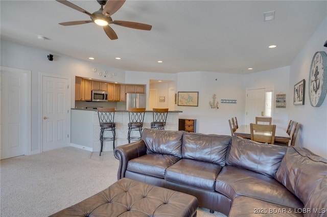 living room featuring light colored carpet and ceiling fan