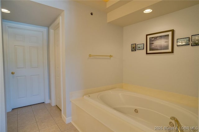 bathroom with a tub to relax in and tile patterned floors