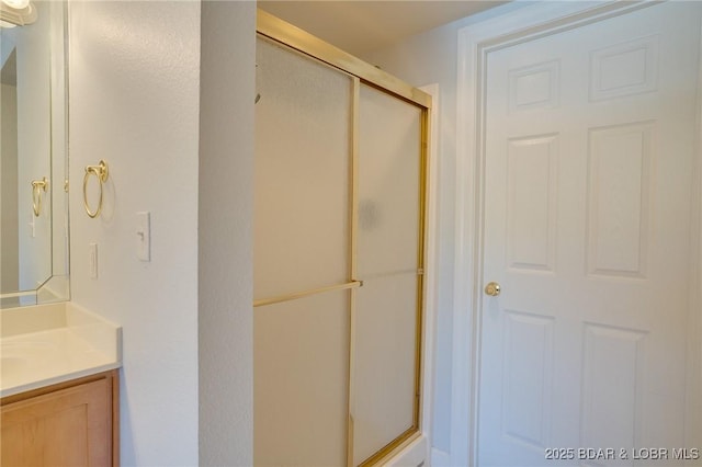 bathroom featuring vanity and a shower with shower door