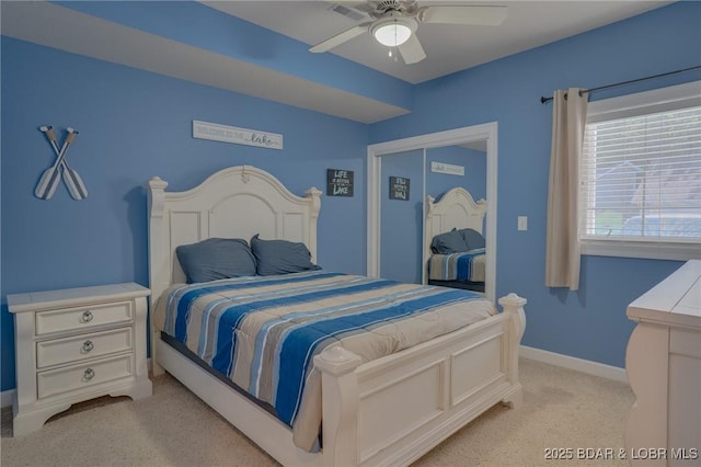 carpeted bedroom featuring ceiling fan and a closet