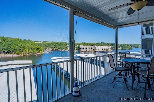 view of patio with a balcony, a water view, and ceiling fan