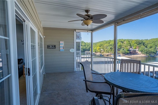 sunroom / solarium featuring a water view and ceiling fan