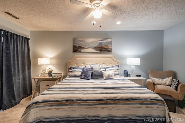 carpeted bedroom with ceiling fan and a textured ceiling