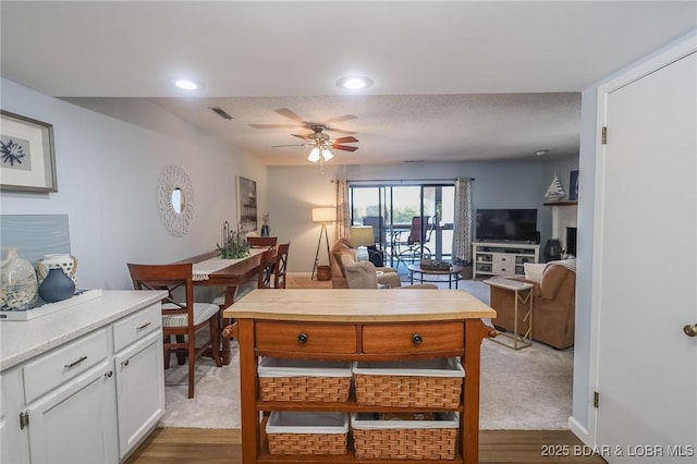 kitchen with white cabinetry, light colored carpet, and ceiling fan