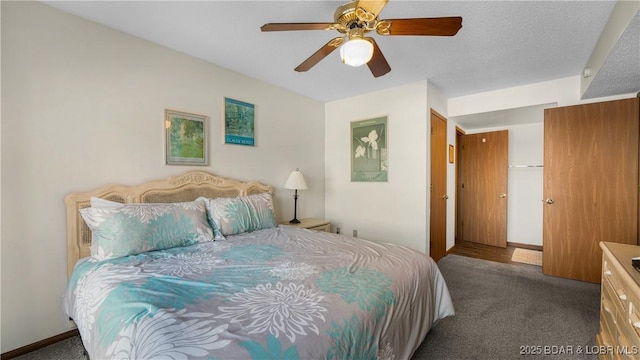 bedroom with ceiling fan, dark carpet, and a textured ceiling