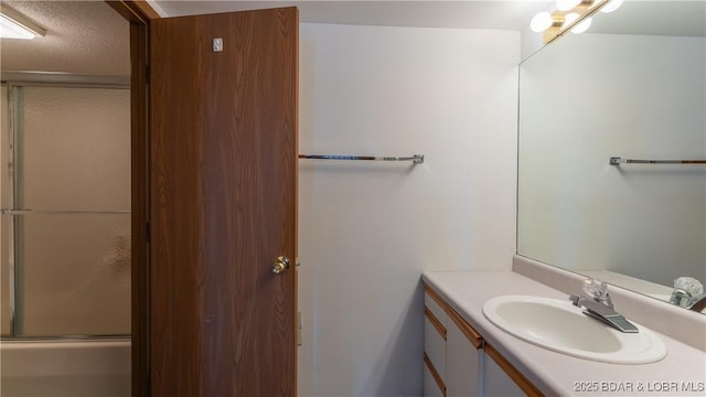 bathroom with vanity and combined bath / shower with glass door