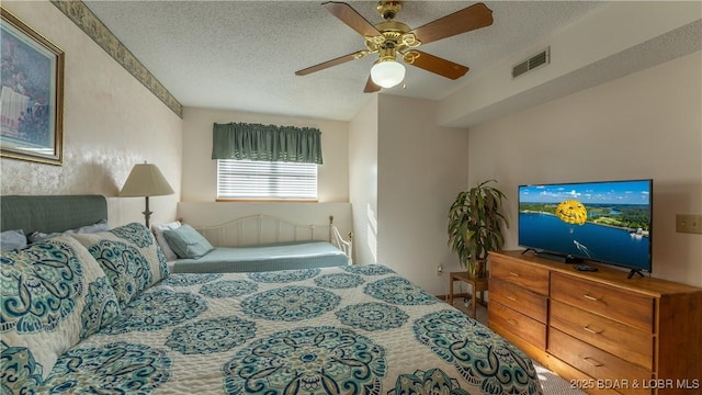 bedroom with ceiling fan and a textured ceiling