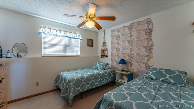 carpeted bedroom featuring ceiling fan and a textured ceiling