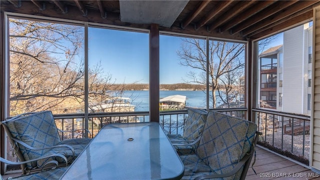 unfurnished sunroom with a water view