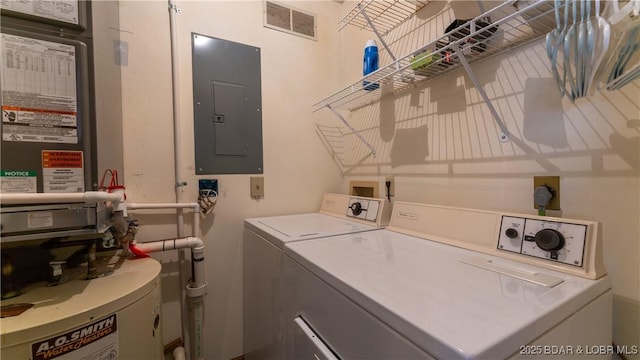 clothes washing area with separate washer and dryer, electric panel, and water heater