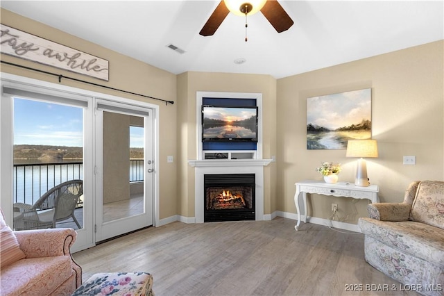 living room with ceiling fan and light wood-type flooring