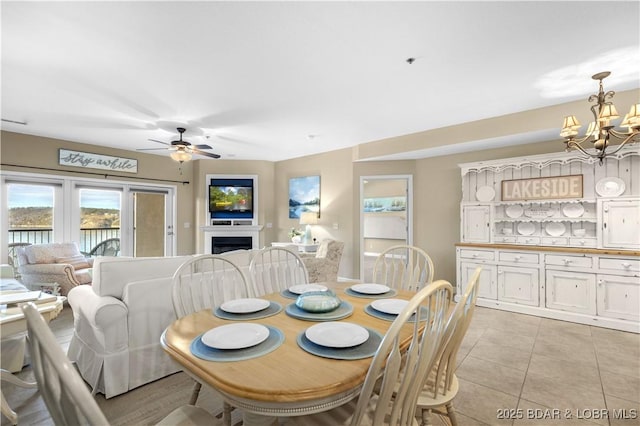 tiled dining room featuring ceiling fan with notable chandelier