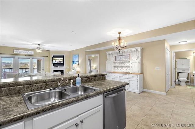 kitchen featuring sink, light tile patterned floors, dishwasher, pendant lighting, and white cabinets