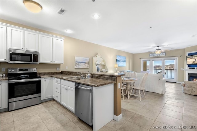 kitchen featuring appliances with stainless steel finishes, kitchen peninsula, sink, and white cabinets