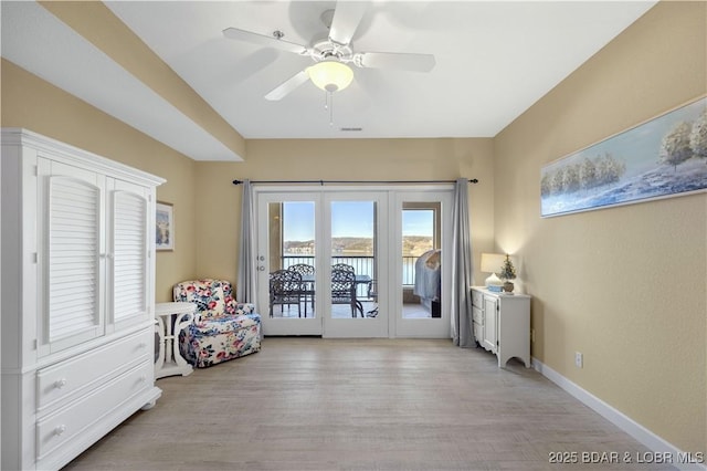 sitting room with ceiling fan and light wood-type flooring