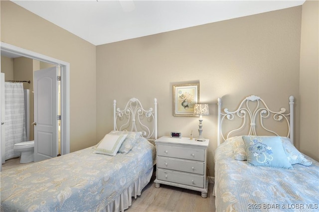 bedroom featuring ensuite bathroom and light hardwood / wood-style flooring