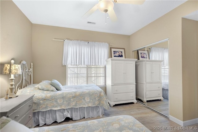 bedroom featuring ceiling fan, a closet, and light wood-type flooring