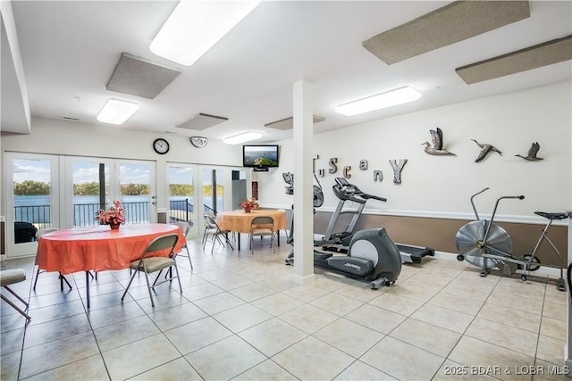 gym with french doors and light tile patterned floors