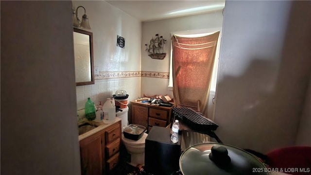 bathroom featuring tile walls, sink, and toilet