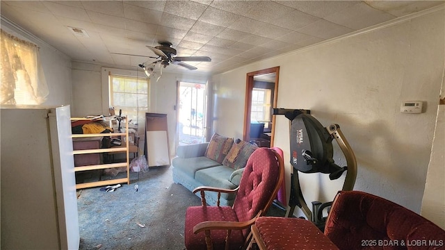 living area featuring ceiling fan, ornamental molding, and carpet